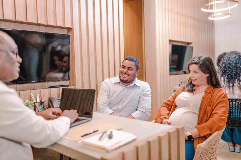 Man and pregnant woman meeting with representative in office.