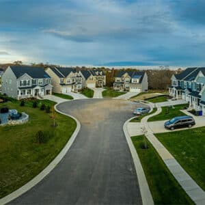 Culdesac at the end of screet with multiple houses, driveways and cars parked out front.