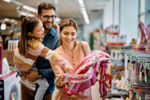 Family of three shopping in store for school bookbag.